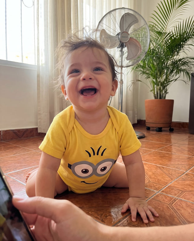 Bebé gateando en el piso con el body amarillo