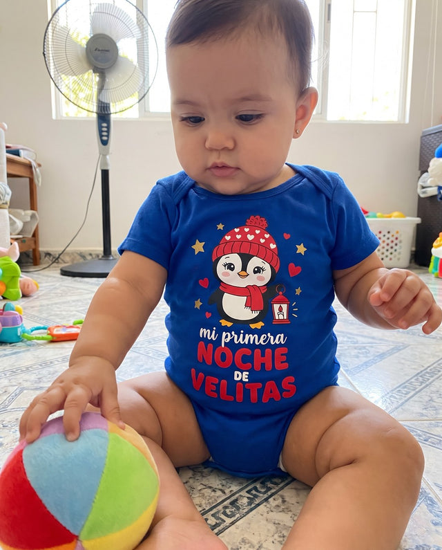 Bebé jugando en el piso con el body azul de las velitas