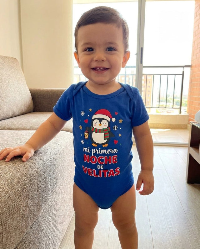 Niño de pie junto al sofá con el body azul