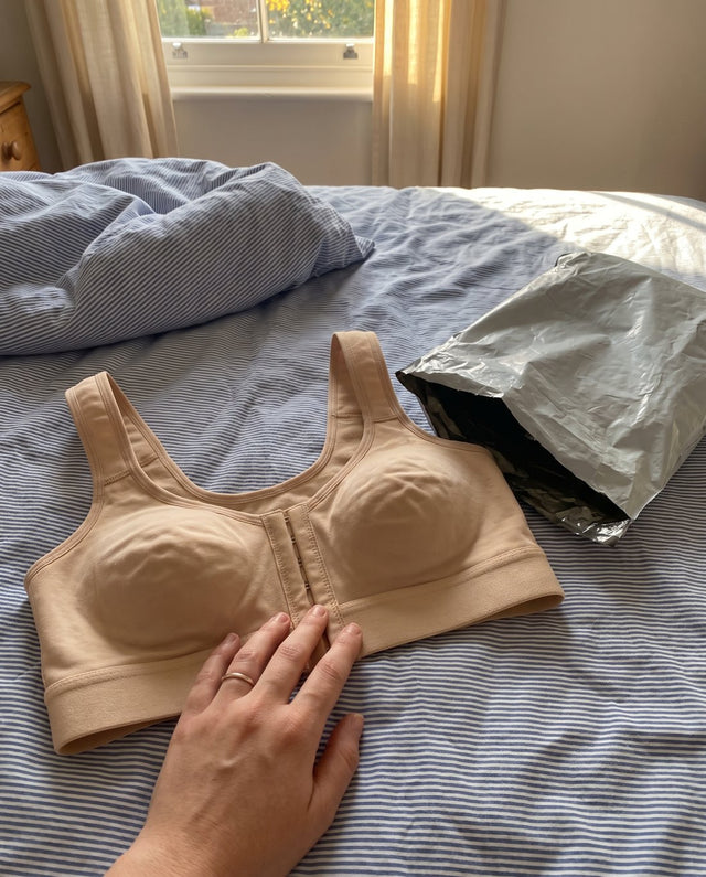 El brasier beige sobre la cama junto a la bolsa de envío
