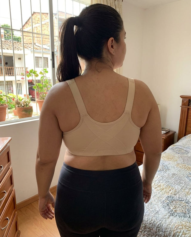 Mujer de espaldas con el brasier beige mostrando los tirantes anchos