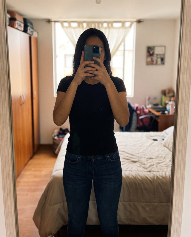 Mujer frente al espejo con camiseta negra ajustada