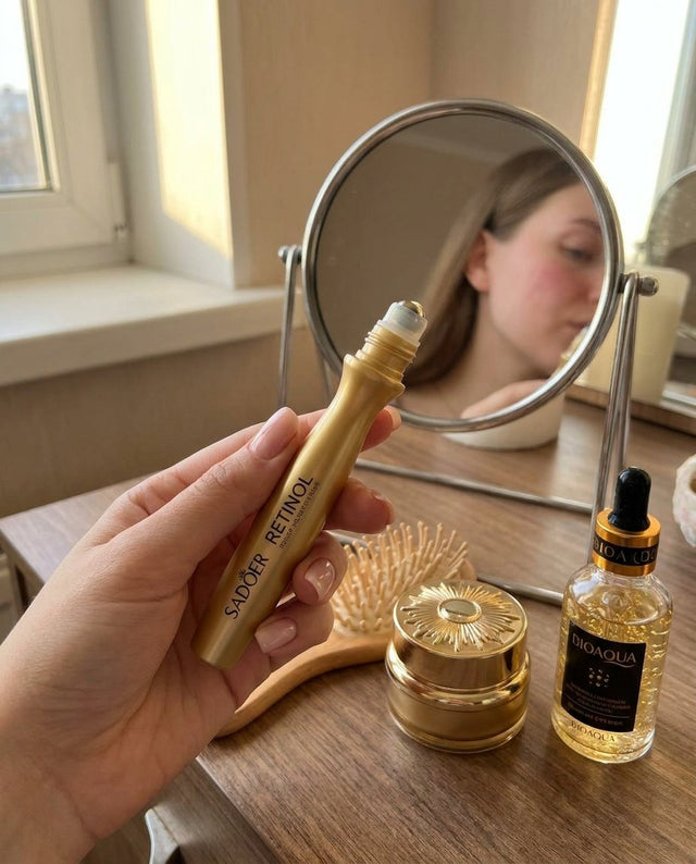 Mano sosteniendo el roller de retinol frente al espejo