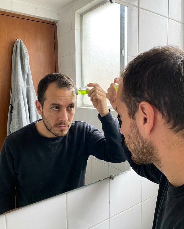 Hombre en Bogotá aplicándose el kit en las entradas frente al espejo
