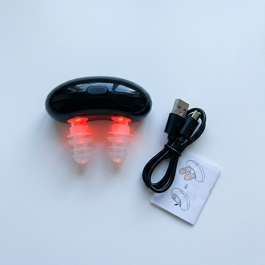 El RespiRelief con su cable de carga y el manual, vistos desde arriba